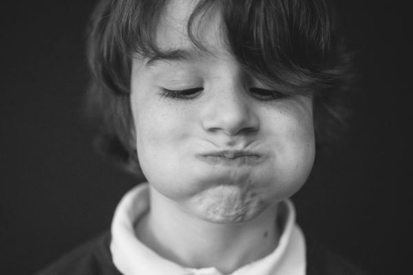 boy with puffed up cheeks school portrait